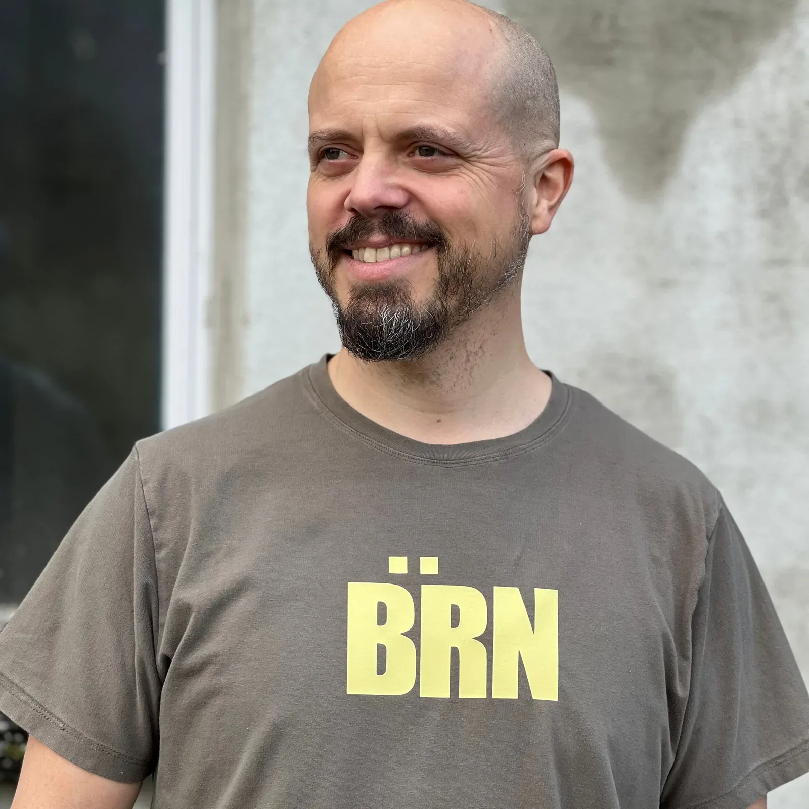 Mann in einem grauen Shirt mit gelbem Bärn-Schriftzug