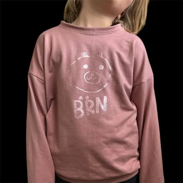Altrosa Shirt mit der Bärn-Kreation von Rhomy junior vor schwarzem Hintergrund