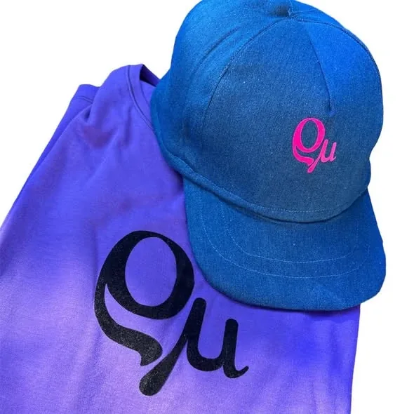 Violettes Shirt und blaue Cap mit aufgebügelten Rhomy-Logos